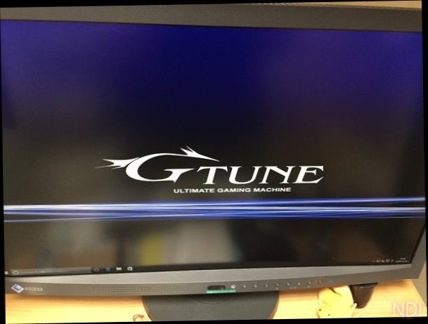新パソコン初起動時のモニタ画面を写した写真。壁紙は濃い藍色の背景に白いG-TUNEのロゴ。